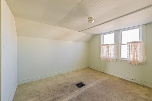 bonus room featuring lofted ceiling and light carpet