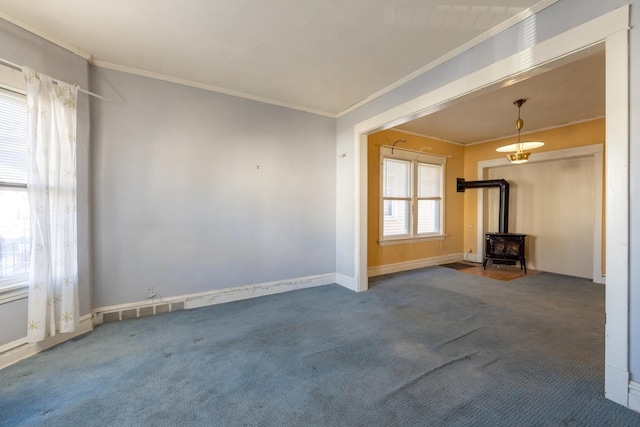 unfurnished living room featuring carpet floors, a wood stove, and crown molding