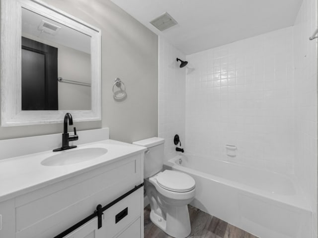 full bathroom with vanity, toilet, wood-type flooring, and tiled shower / bath