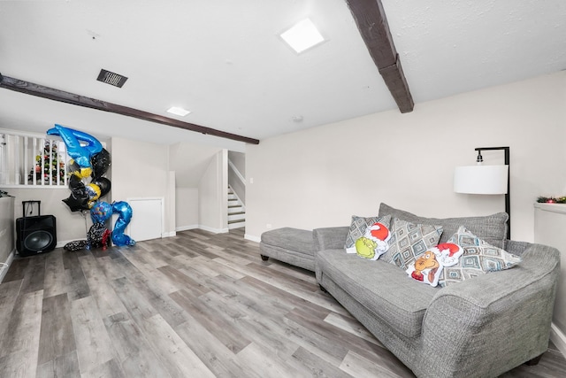 living room featuring beamed ceiling and wood-type flooring