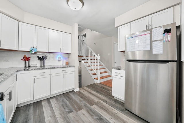 kitchen featuring stainless steel fridge and white cabinetry