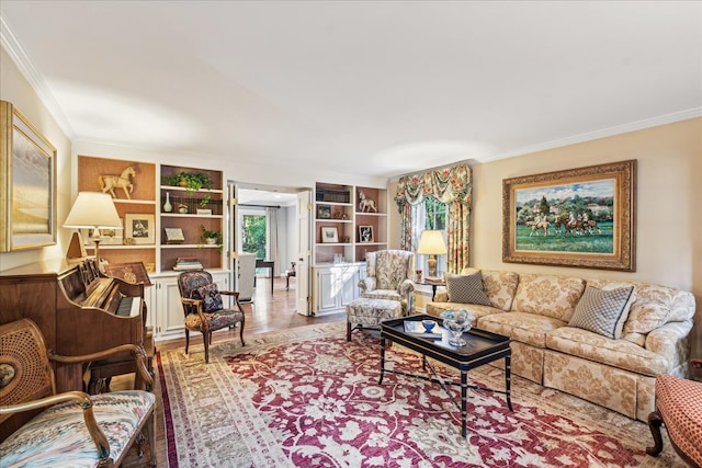 living room with crown molding, built in shelves, and light hardwood / wood-style floors