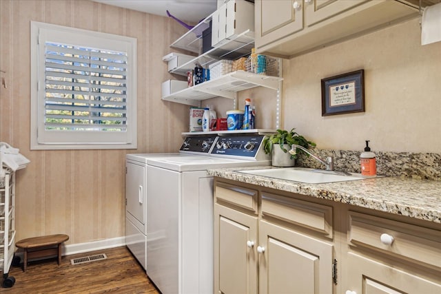 clothes washing area featuring cabinets, independent washer and dryer, sink, and dark hardwood / wood-style flooring