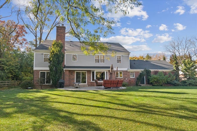 rear view of house with a patio and a lawn