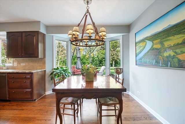 dining space with a notable chandelier, wood-type flooring, and a wealth of natural light