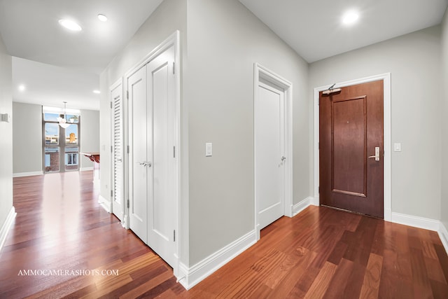 hall featuring dark hardwood / wood-style floors and a chandelier