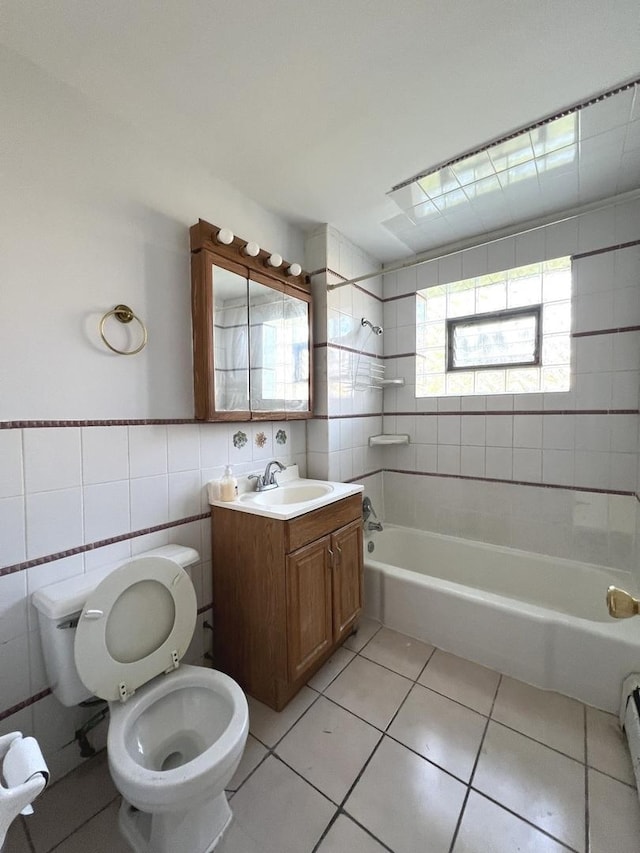 full bathroom featuring vanity, tile patterned floors, tiled shower / bath combo, toilet, and tile walls