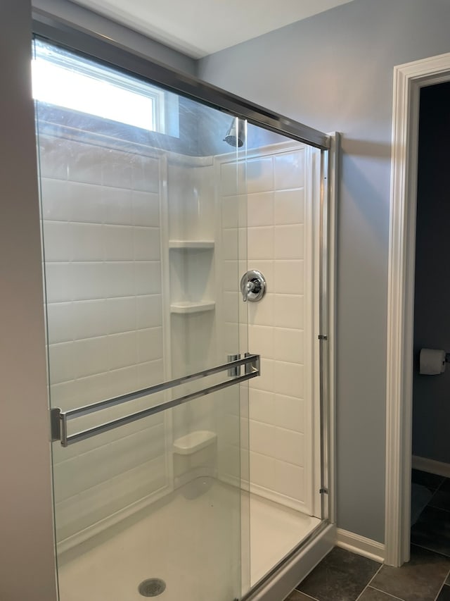 bathroom featuring a shower with door and tile patterned flooring