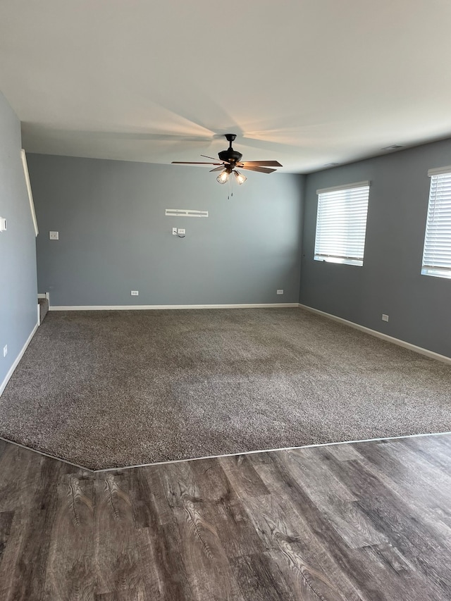 spare room featuring dark wood-type flooring and ceiling fan