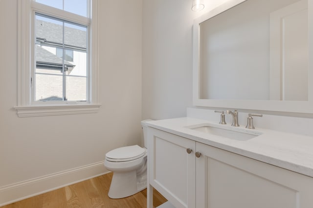 bathroom featuring toilet, hardwood / wood-style floors, and vanity