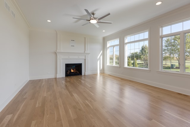 unfurnished living room with light hardwood / wood-style floors, ornamental molding, and ceiling fan