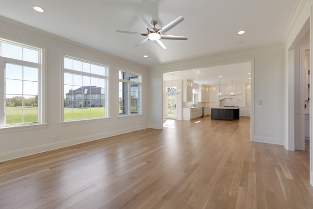 unfurnished living room with crown molding, a healthy amount of sunlight, hardwood / wood-style flooring, and ceiling fan