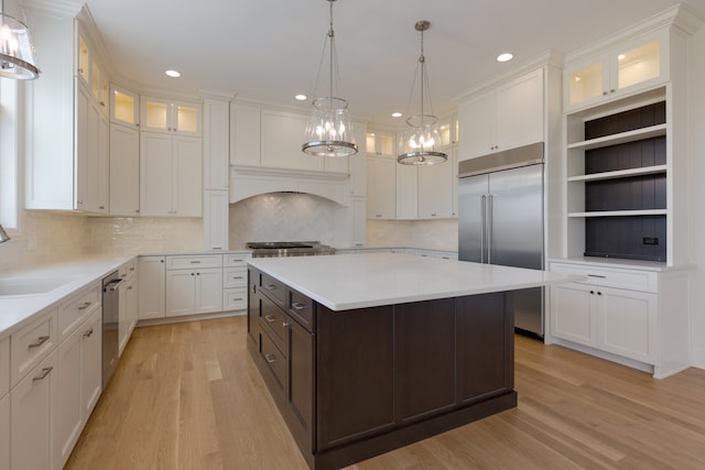 kitchen with a center island, appliances with stainless steel finishes, light wood-type flooring, and white cabinets