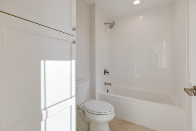 bathroom with tiled shower / bath combo, toilet, and tile patterned flooring