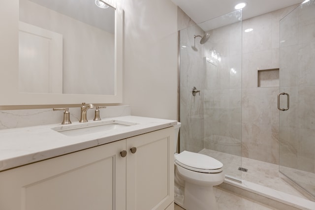 bathroom with vanity, a shower with shower door, and toilet