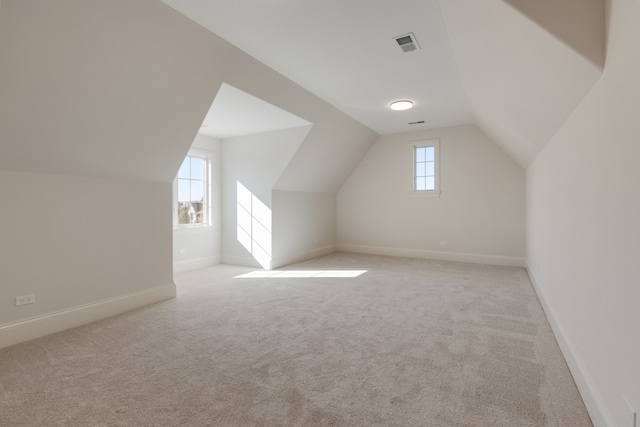 additional living space with light carpet and lofted ceiling