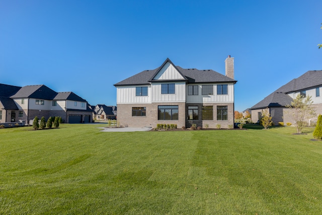 rear view of house featuring a lawn