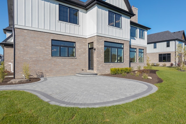 back of house featuring a patio and a yard