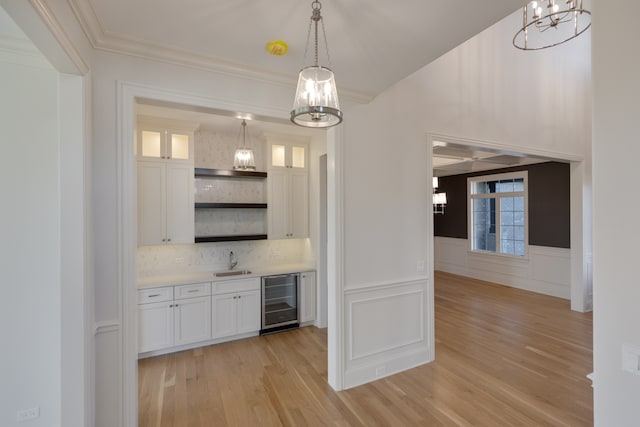 kitchen with white cabinetry, decorative backsplash, wine cooler, and decorative light fixtures