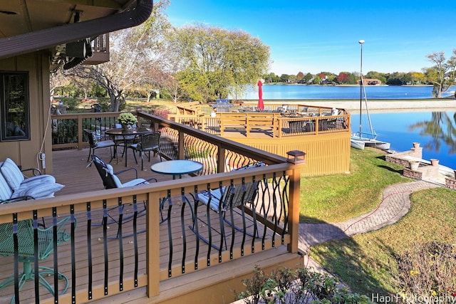 wooden terrace featuring a lawn and a water view