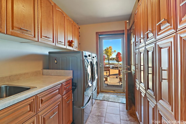 laundry area featuring cabinets, independent washer and dryer, and tile patterned floors