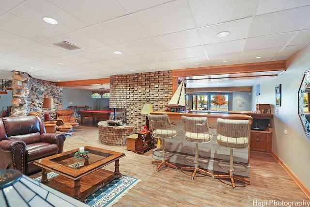 living room featuring billiards, bar, a paneled ceiling, and light hardwood / wood-style floors