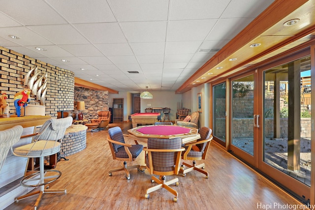 dining space with a paneled ceiling, billiards, and light wood-type flooring