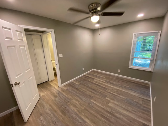 unfurnished bedroom featuring dark hardwood / wood-style flooring, a closet, and ceiling fan