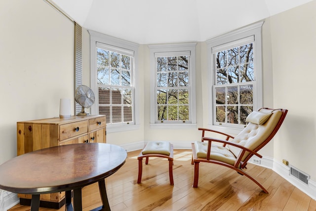 living area with baseboards and light wood finished floors