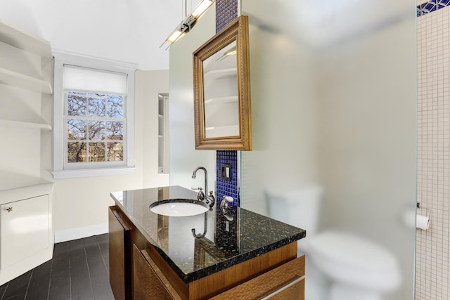 bathroom with vanity, baseboards, and wood finished floors
