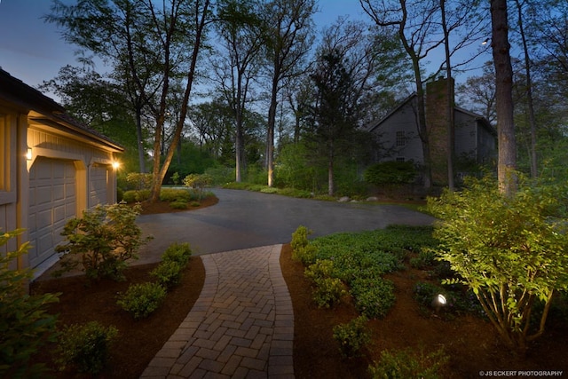 yard at dusk featuring a garage