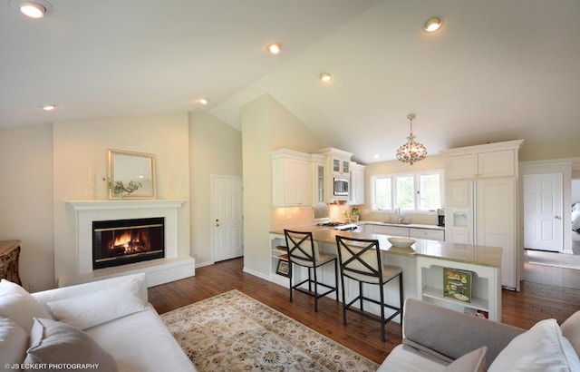 living room with high vaulted ceiling, dark hardwood / wood-style floors, and a notable chandelier