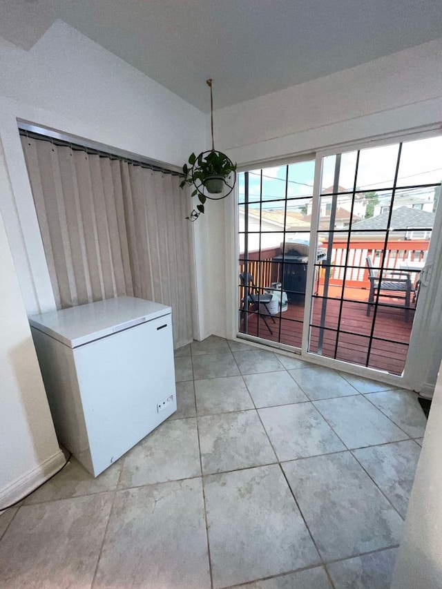 unfurnished dining area featuring light tile patterned floors and a chandelier