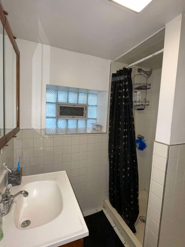 bathroom featuring vanity, tile walls, and a shower with shower curtain