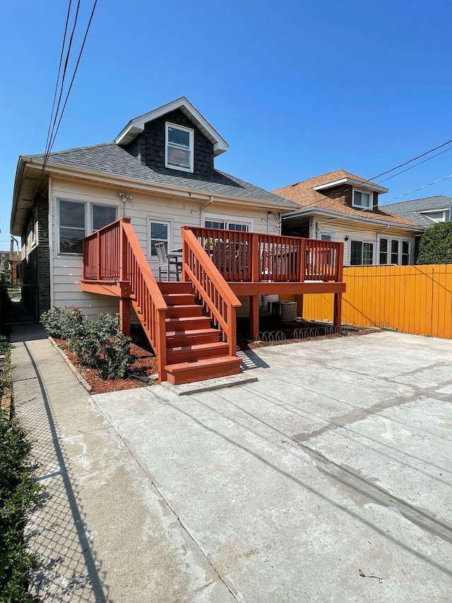 rear view of property featuring a wooden deck