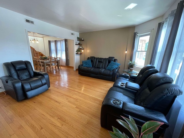 living room featuring a chandelier and light wood-type flooring