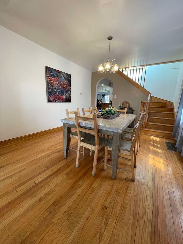 dining space with light hardwood / wood-style flooring and an inviting chandelier