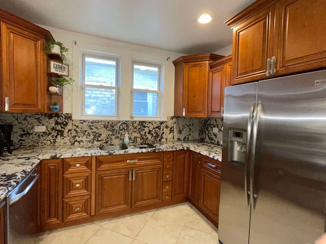 kitchen featuring decorative backsplash, light stone counters, appliances with stainless steel finishes, light tile patterned flooring, and sink