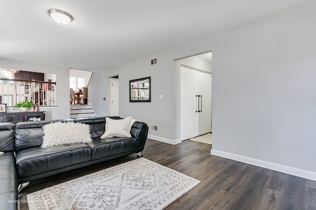 living room with dark wood-type flooring and an inviting chandelier