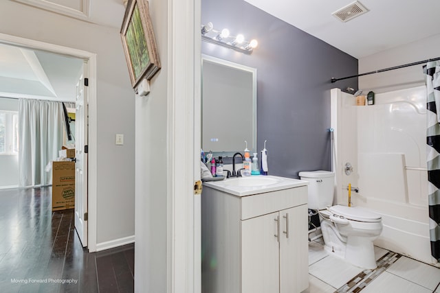 full bathroom with hardwood / wood-style floors, vanity, shower / bath combination, and toilet