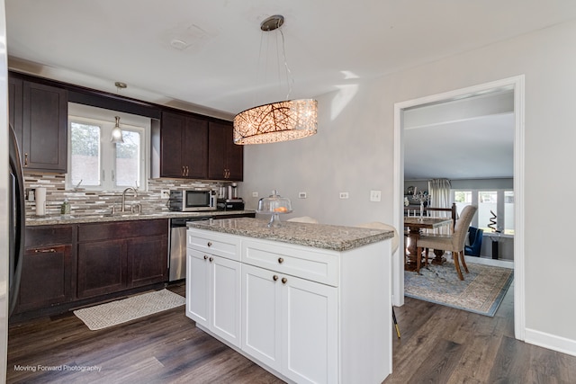 kitchen with dishwasher, white cabinets, hanging light fixtures, dark hardwood / wood-style floors, and plenty of natural light