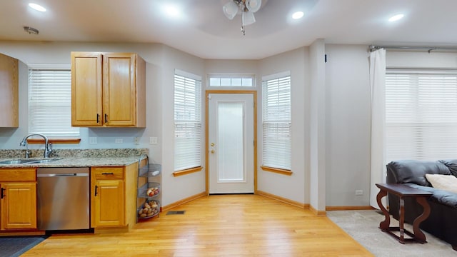 kitchen with stainless steel dishwasher, light hardwood / wood-style floors, ceiling fan, and sink