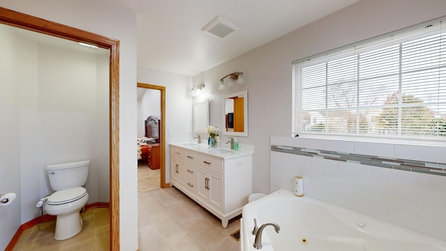 bathroom featuring tile patterned flooring, vanity, toilet, and a tub to relax in