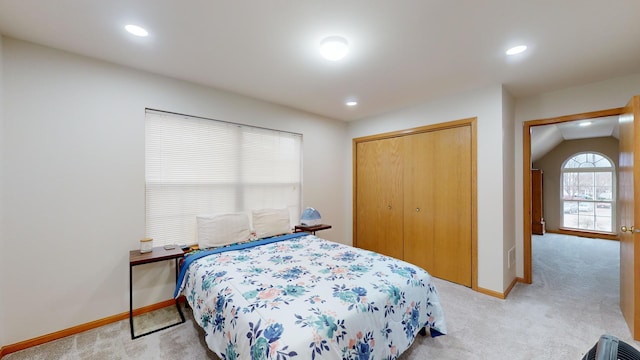 carpeted bedroom featuring lofted ceiling and a closet