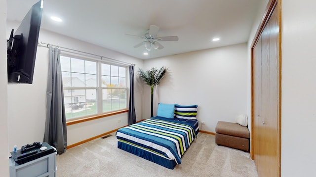 carpeted bedroom with ceiling fan and a closet