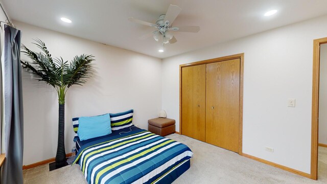 bedroom featuring ceiling fan, light carpet, and a closet