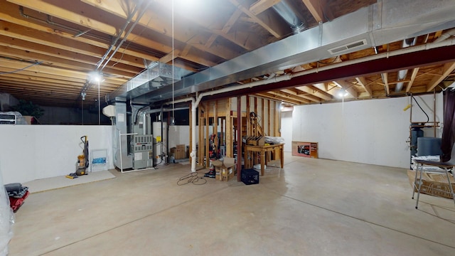 basement featuring water heater and heating unit