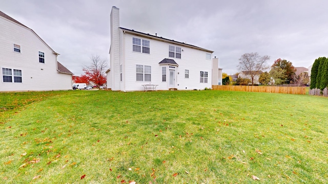 rear view of property featuring a yard