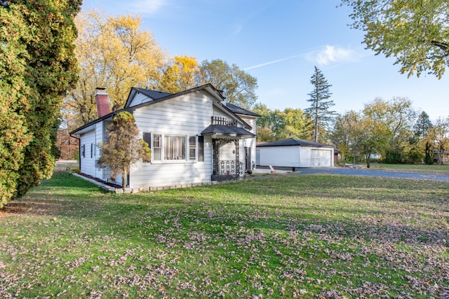 view of front of home with a front yard, an outbuilding, and a garage