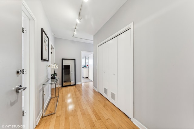 hall featuring light hardwood / wood-style flooring and rail lighting